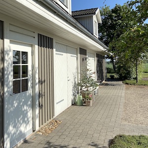 View of the building with a bench in front of the garage